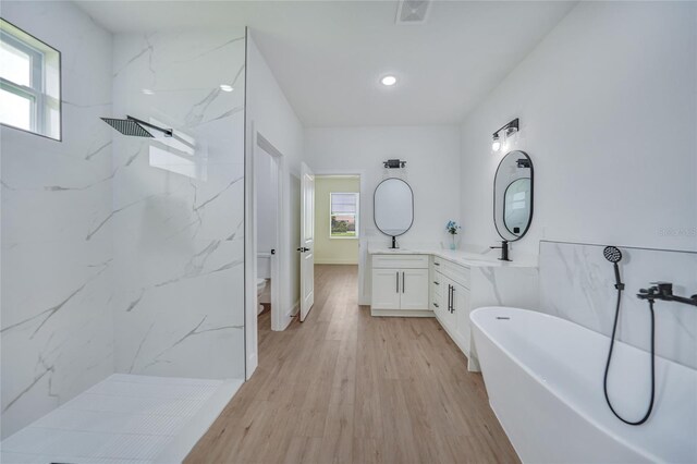 full bathroom with separate shower and tub, plenty of natural light, wood-type flooring, and vanity