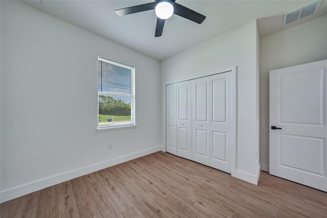 unfurnished bedroom featuring a closet, ceiling fan, and light hardwood / wood-style flooring