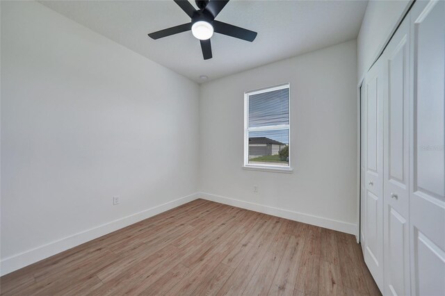 unfurnished bedroom featuring light hardwood / wood-style flooring, ceiling fan, and a closet