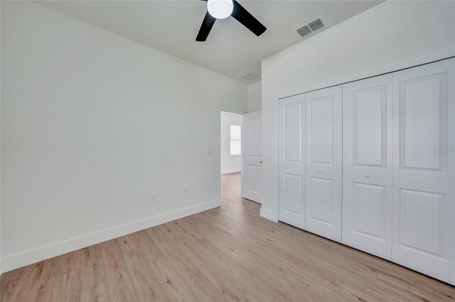 unfurnished bedroom with light hardwood / wood-style flooring, ceiling fan, and a closet