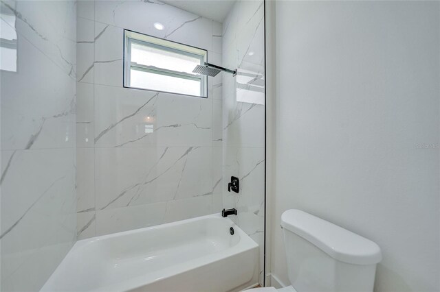 bathroom featuring toilet and tiled shower / bath combo