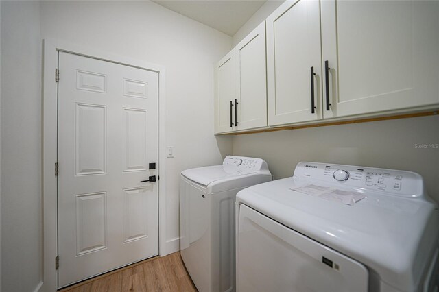 laundry area featuring independent washer and dryer, cabinets, and light hardwood / wood-style floors