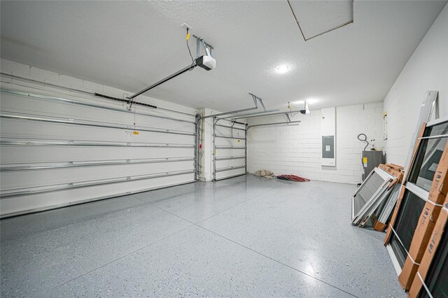 garage featuring electric panel, electric water heater, and a garage door opener