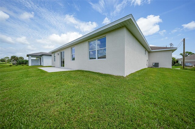 rear view of property with a patio area, a yard, and central air condition unit