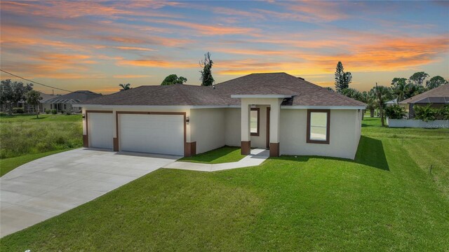 prairie-style house featuring a lawn and a garage