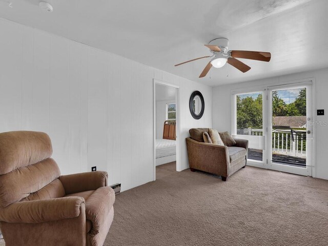 sitting room with ceiling fan and light carpet