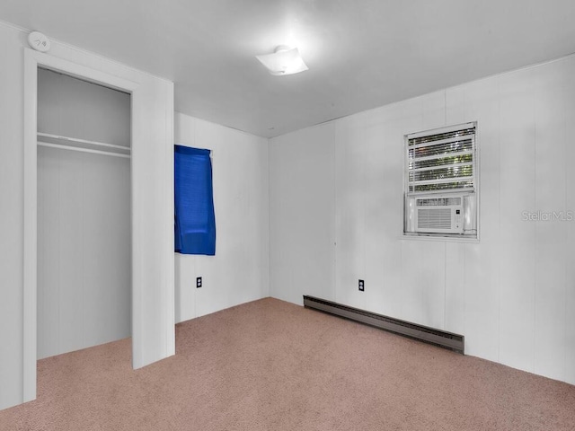 unfurnished bedroom with a baseboard heating unit, carpet flooring, a closet, and cooling unit