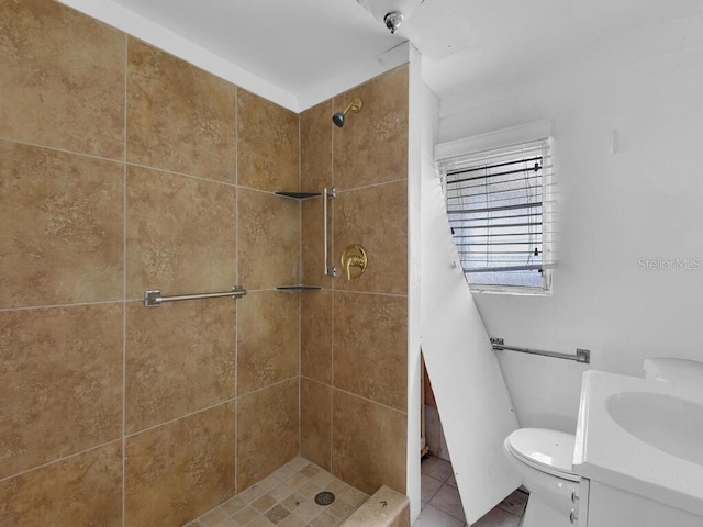 bathroom with tiled shower, vanity, toilet, and tile patterned floors