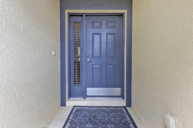 entrance to property featuring stucco siding