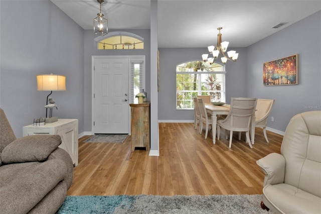 entryway with light hardwood / wood-style floors and a notable chandelier