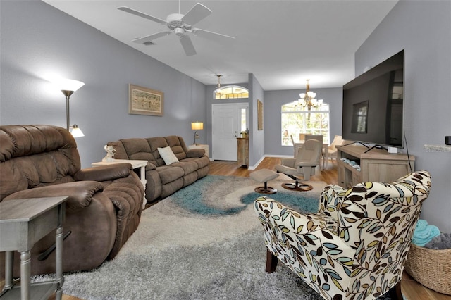 living room with ceiling fan with notable chandelier and light wood-type flooring