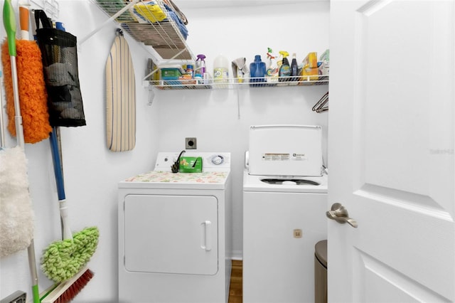 clothes washing area with independent washer and dryer and hardwood / wood-style flooring