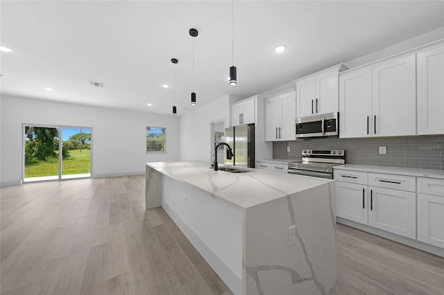 kitchen featuring a sink, stainless steel appliances, tasteful backsplash, and visible vents