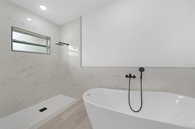 bathroom featuring tile walls, separate shower and tub, and wood-type flooring