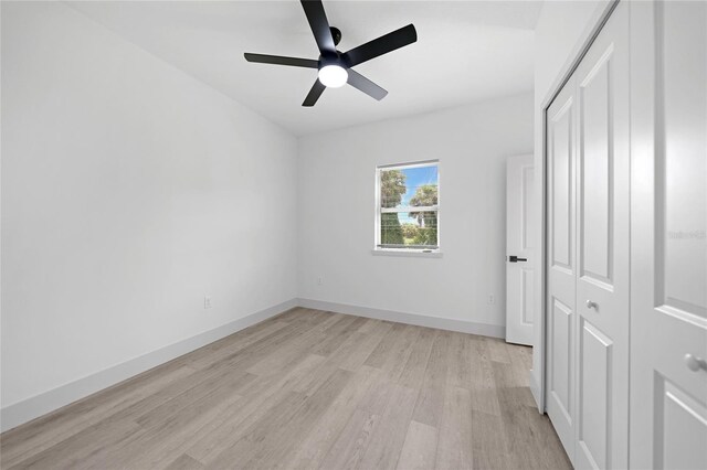 unfurnished bedroom with ceiling fan, a closet, and light hardwood / wood-style floors