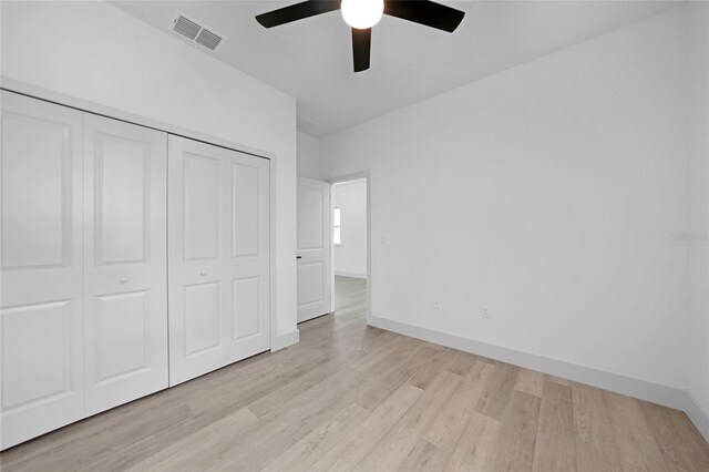 unfurnished bedroom featuring light hardwood / wood-style flooring, ceiling fan, and a closet