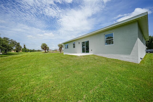 rear view of property featuring a lawn and a patio area