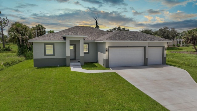 view of front facade with stucco siding, an attached garage, driveway, and a front lawn