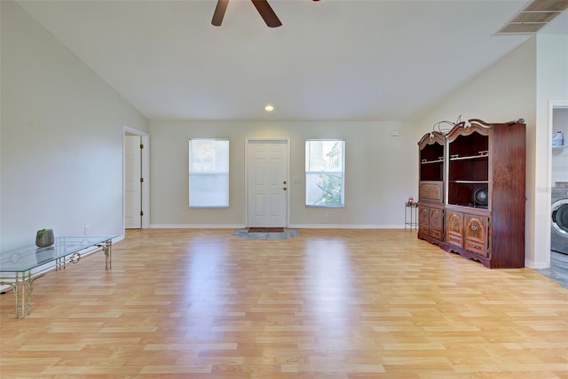 unfurnished living room featuring washer / clothes dryer, ceiling fan, and light wood-type flooring