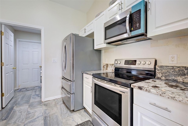 kitchen with white cabinets, appliances with stainless steel finishes, and light stone countertops