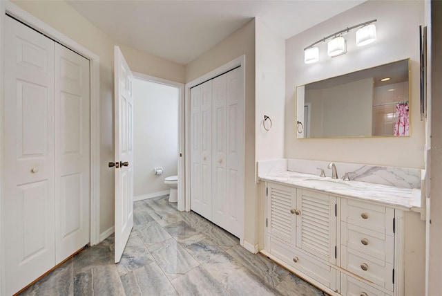 bathroom featuring vanity, toilet, and a shower