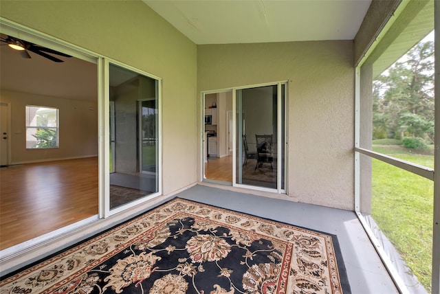 unfurnished sunroom featuring ceiling fan