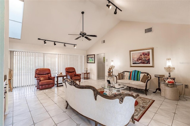 living room featuring lofted ceiling, rail lighting, light tile patterned flooring, and ceiling fan