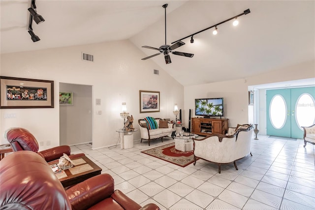 tiled living room featuring track lighting, ceiling fan, and lofted ceiling