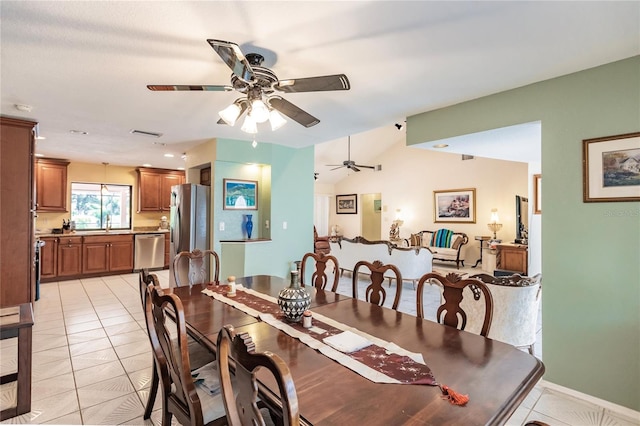 tiled dining room with ceiling fan and sink