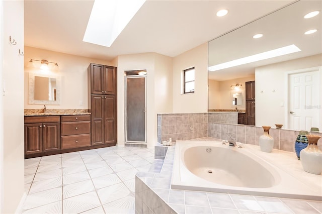 bathroom with vanity, a skylight, and separate shower and tub