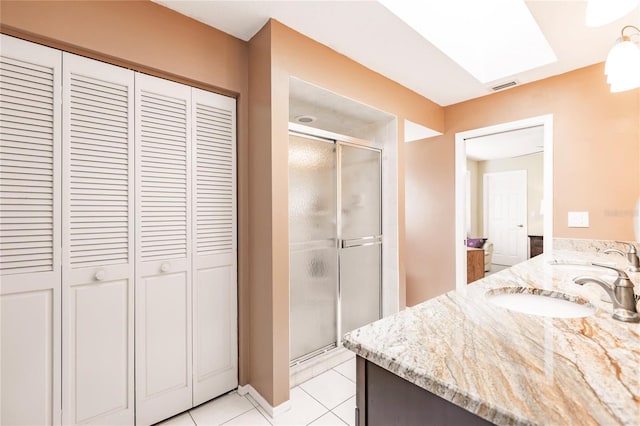 bathroom with vanity, tile patterned flooring, and a shower with door