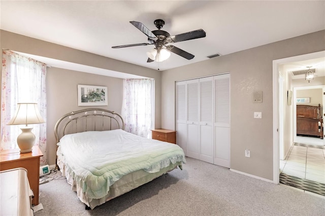 carpeted bedroom with ceiling fan and a closet