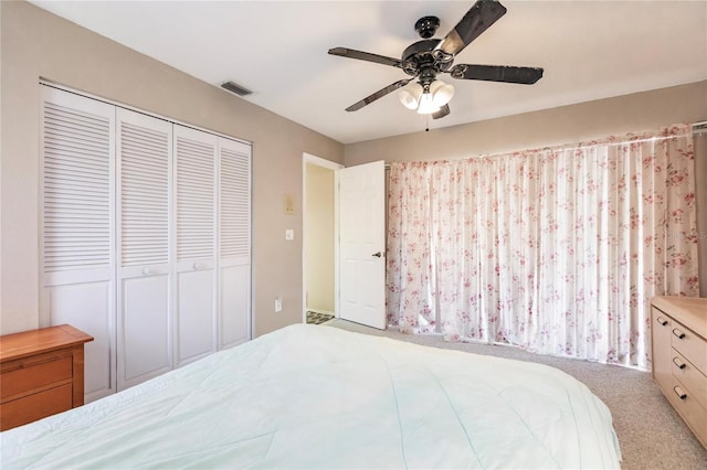 bedroom with a closet, ceiling fan, and light carpet