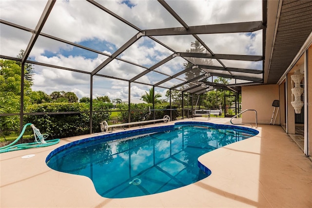 view of swimming pool with glass enclosure and a patio area