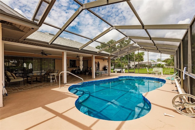 view of swimming pool featuring ceiling fan, a lanai, and a patio area