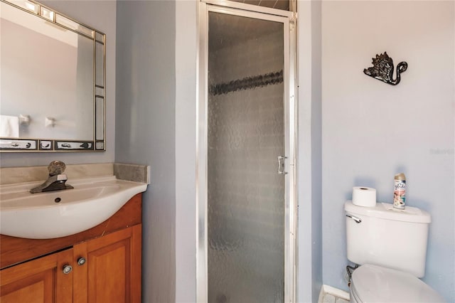 bathroom featuring a shower with door, vanity, and toilet