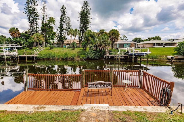 view of dock with a water view and a yard