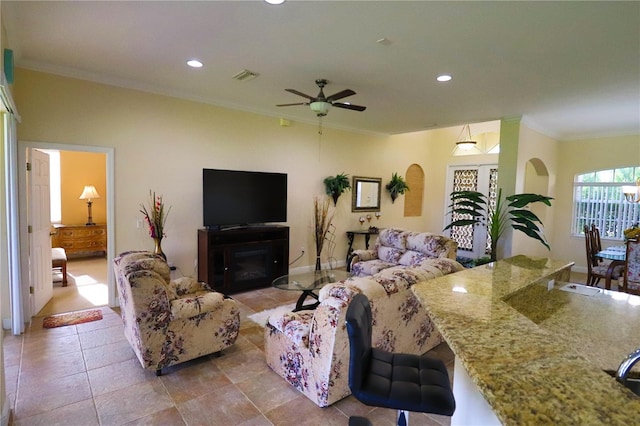 living room featuring a fireplace, ornamental molding, and ceiling fan