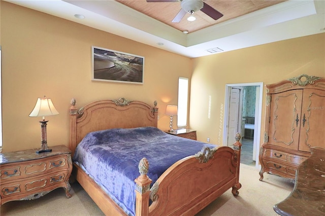 carpeted bedroom featuring a raised ceiling, connected bathroom, and ceiling fan