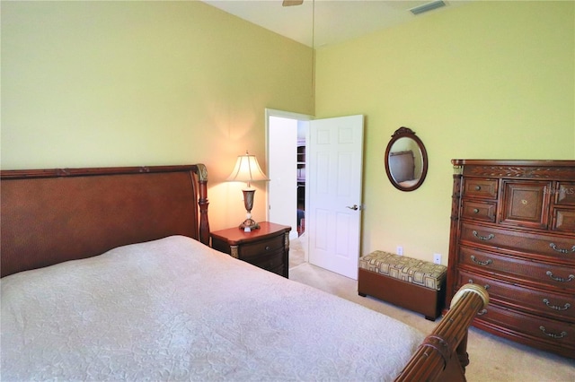 carpeted bedroom featuring ceiling fan and a towering ceiling