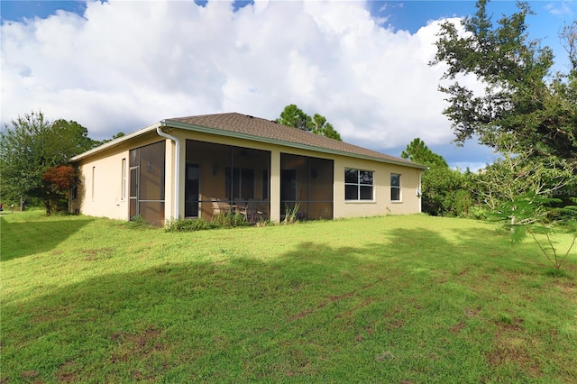 back of property with a lawn and a sunroom