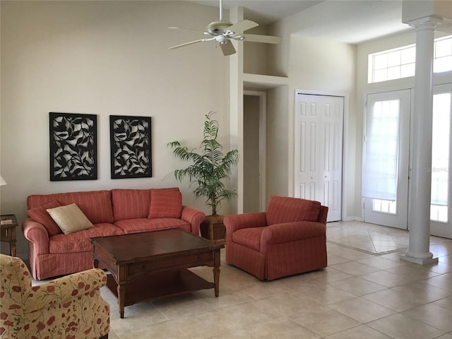 living room with a healthy amount of sunlight, ceiling fan, decorative columns, and light tile patterned flooring