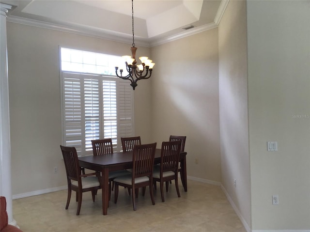 dining area with a tray ceiling, crown molding, and a chandelier