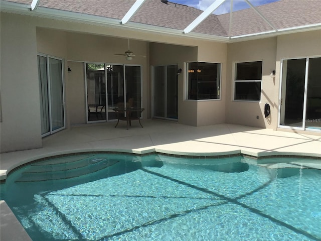 view of pool with ceiling fan, a patio area, and glass enclosure