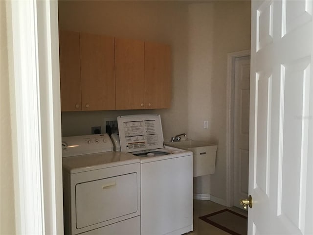 laundry area featuring cabinets, washer and dryer, and sink