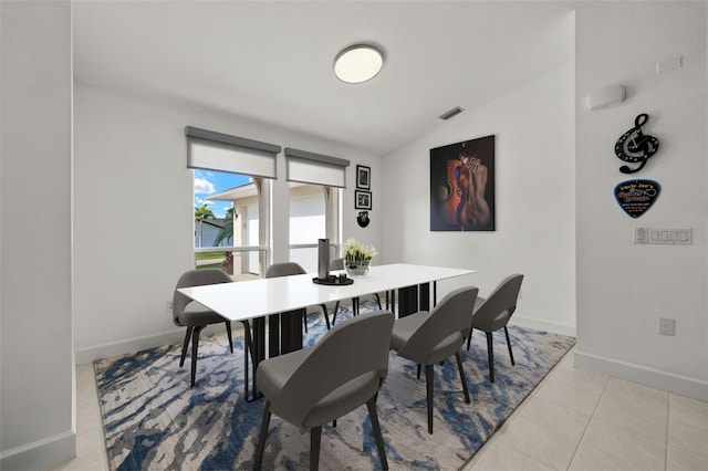 tiled dining room featuring lofted ceiling