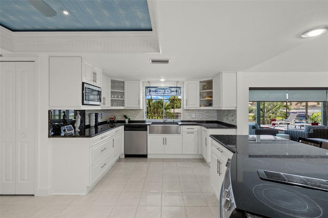 kitchen featuring dark stone countertops, plenty of natural light, backsplash, and stainless steel appliances