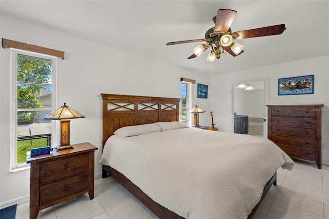 tiled bedroom with ceiling fan and ensuite bath