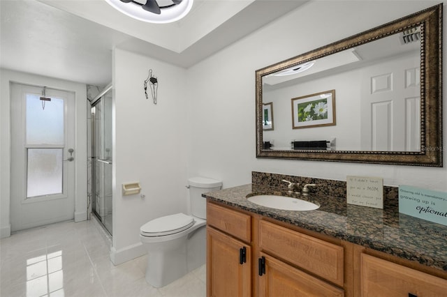 bathroom with vanity, toilet, a shower with shower door, and tile patterned floors