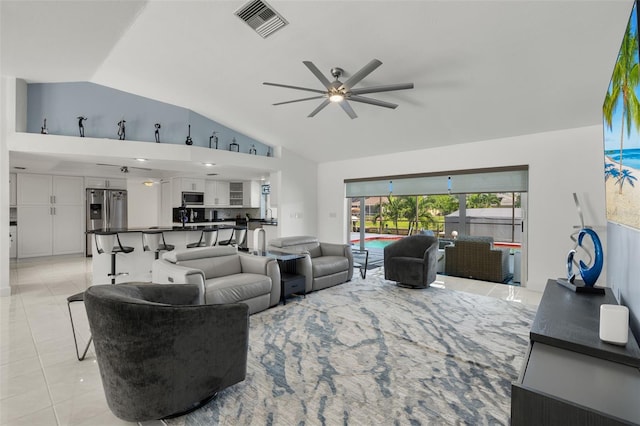 living area with light tile patterned floors, vaulted ceiling, visible vents, and a ceiling fan